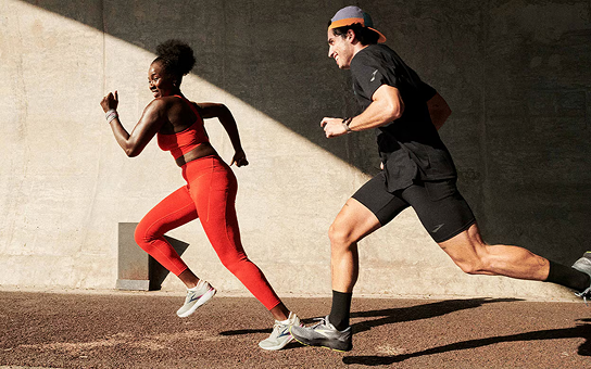 Duas pessoas correndo, uma mulher e um homem, com roupas esportivas